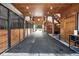 Interior view of a barn featuring wooden stalls, ceiling lights, and an open doorway to outside at 206 Savanna Estates Ct, Canton, GA 30115