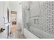 Bathroom showcasing a tiled shower/tub combination with glass door and wood-look flooring at 206 Savanna Estates Ct, Canton, GA 30115
