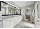 Elegant bathroom featuring dual vanities, a glass shower, and tiled flooring at 206 Savanna Estates Ct, Canton, GA 30115