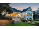 Spacious backyard with a deck, patio seating, lush landscaping, and charming architectural details at twilight at 206 Savanna Estates Ct, Canton, GA 30115