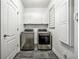 Well-lit laundry room with slate flooring and modern washer and dryer units at 206 Savanna Estates Ct, Canton, GA 30115
