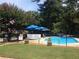 Community pool surrounded by lush greenery with blue umbrellas and lounge chairs for relaxing by the water at 3117 Reeves Se St, Smyrna, GA 30080