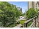 Balcony view showcasing city skyline framed by lush green trees at 700 Park Regency Ne Pl # 703, Atlanta, GA 30326