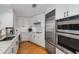 Bright kitchen features white cabinets, marble countertops, stainless steel appliances and wood floors at 700 Park Regency Ne Pl # 703, Atlanta, GA 30326