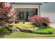 Landscaped backyard with lush greenery, rocks, and a patio area with comfortable seating at 164 Inwood Walk, Woodstock, GA 30188