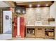 Inviting bar area featuring a red refrigerator, brick backsplash, and wood cabinetry at 164 Inwood Walk, Woodstock, GA 30188