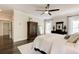 Bright bedroom features a ceiling fan, dark hardwood floors, and a large armoire for storage at 164 Inwood Walk, Woodstock, GA 30188