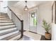Inviting foyer with hardwood floors, elegant staircase, and a view of the front door with decorative wreath at 164 Inwood Walk, Woodstock, GA 30188