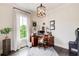 Charming home office with a wooden desk, a patterned rug, and natural light from a large window at 164 Inwood Walk, Woodstock, GA 30188