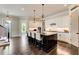 Elegant kitchen with white cabinets, a dark island with seating, and stainless steel appliances, open layout at 164 Inwood Walk, Woodstock, GA 30188