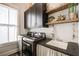 Well-organized laundry room with dark cabinets, open shelving, a sink and modern appliances at 164 Inwood Walk, Woodstock, GA 30188