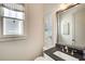 Stylish powder room with a dark countertop, modern fixtures, and a decorative wall mirror at 164 Inwood Walk, Woodstock, GA 30188