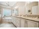 Bathroom featuring a double vanity, bathtub, and large window at 1800 Hunters Moon Dr, Alpharetta, GA 30005