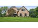 Elegant brick home with a well-manicured lawn and mature landscaping offers classic curb appeal at 1800 Hunters Moon Dr, Alpharetta, GA 30005