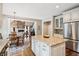 Open-concept kitchen with a center island, stainless steel refrigerator, and views into the living area at 1800 Hunters Moon Dr, Alpharetta, GA 30005