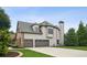 Exterior angle of two-car garage, stone and siding finishes, and chimney at 1800 Hunters Moon Dr, Alpharetta, GA 30005