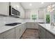 Well-lit kitchen featuring gray cabinets, stainless steel appliances, a tile backsplash, and hardwood floors at 193 Treeline Trl, Canton, GA 30115
