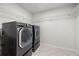 Laundry room with modern black washer and dryer, tile floors and wire shelving at 193 Treeline Trl, Canton, GA 30115