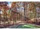 Beautiful, wooded backyard with a small retaining wall on a sunny, autumn day at 271 Brooks Rackley Rd, Dallas, GA 30157