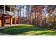 Lovely backyard view of the brick home, green grass, trees, and retaining wall at 271 Brooks Rackley Rd, Dallas, GA 30157