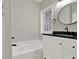 Bathroom featuring a shower-tub combo with black hardware, a round mirror and a vanity at 271 Brooks Rackley Rd, Dallas, GA 30157