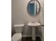 This powder room features a pedestal sink, round mirror, and modern fixtures at 558 Fairview Oak Pl, Dallas, GA 30157