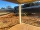 Backyard showing unfinished area in need of landscaping, with a covered patio at 616 Rodeo Dr, Auburn, GA 30011