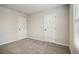 Neutral bedroom featuring gray carpet, white trim and doors, plus a large window at 616 Rodeo Dr, Auburn, GA 30011