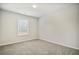 Clean, empty bedroom with gray carpet, white trim, and a window letting in natural light at 616 Rodeo Dr, Auburn, GA 30011