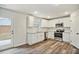 A kitchen area with stainless appliances, white cabinetry, and a view of the fenced backyard at 616 Rodeo Dr, Auburn, GA 30011