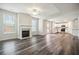 Open living room with fireplace, luxury vinyl plank flooring, and bright white kitchen at 616 Rodeo Dr, Auburn, GA 30011