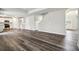 Open living room with luxury vinyl plank flooring, staircase, and bright white kitchen at 616 Rodeo Dr, Auburn, GA 30011