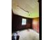 A dilapidated bedroom with damaged ceiling, dark paneling, and worn carpeting, highlighting the need for repair at 1934 Apache Se Trl, Atlanta, GA 30316