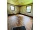 Dilapidated bedroom with hardwood flooring and two windows providing natural light at 1934 Apache Se Trl, Atlanta, GA 30316