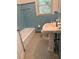 Traditional-style bathroom features light blue tiling and a pedestal sink beneath a window at 2225 Harold Se Ln, Smyrna, GA 30080