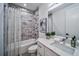 Well-lit bathroom features a shower-tub combo with marble accents, a sleek vanity, and modern fixtures at 235 W Marietta St, Canton, GA 30114