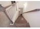 Carpeted staircase featuring stained wood handrail and painted white spindles at 4175 Spring Valley Cir, Tucker, GA 30084