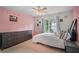 Bright, bedroom featuring pink walls, a cozy bed and a dresser at 7071 Glen Cove Ln, Stone Mountain, GA 30087