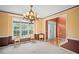 Inviting dining area with large windows, elegant chandelier, and classic wainscoting at 7071 Glen Cove Ln, Stone Mountain, GA 30087