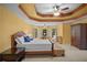 Spacious main bedroom boasts tray ceiling, ceiling fan, and large windows at 7071 Glen Cove Ln, Stone Mountain, GA 30087