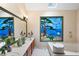 Bright bathroom featuring unique stained glass window, soaking tub, and double sinks at 735 Wood Valley Trce, Roswell, GA 30076