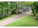 Two-story traditional home with a long drive and a lush green lawn, surrounded by mature trees at 735 Wood Valley Trce, Roswell, GA 30076