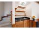 Wet bar area with wooden cabinets, sink, and storage shelves for glasses and drinks at 735 Wood Valley Trce, Roswell, GA 30076