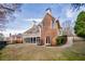 Expansive backyard with covered patio, lush lawn, and mature trees, ideal for outdoor living at 2760 Sugarloaf Club Dr, Duluth, GA 30097
