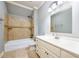Neutral bathroom featuring a white single sink vanity and a shower-tub combination with tan tile surround at 2760 Sugarloaf Club Dr, Duluth, GA 30097