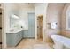 Bright bathroom with stylish blue cabinets, beige tile floors, and a walk-in closet at 2760 Sugarloaf Club Dr, Duluth, GA 30097