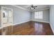 Spacious bedroom with hardwood floors, light-blue walls, a ceiling fan, and a door to an ensuite bathroom at 2760 Sugarloaf Club Dr, Duluth, GA 30097