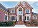 Striking two-story brick home featuring a grand arched entryway and meticulously maintained landscaping at 2760 Sugarloaf Club Dr, Duluth, GA 30097