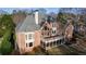 Exterior view of a brick house with a balcony, porch, patio, and large windows at 2760 Sugarloaf Club Dr, Duluth, GA 30097