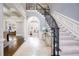 Elegant foyer with a curved staircase, marble floors, and an arched entrance to the living spaces at 2760 Sugarloaf Club Dr, Duluth, GA 30097